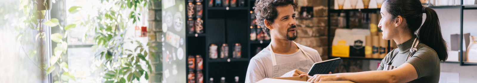 Two workers in a small shop talking